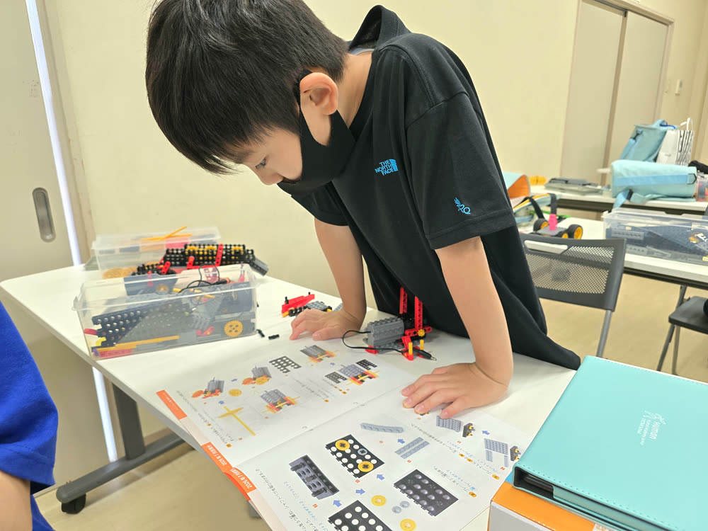 立ち上がって組み立てに集中する生徒